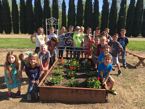 students posing around a flower bed